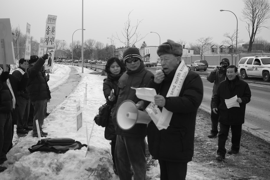 탈북자 장수연 씨가 2013년 오타와 주재 중국 대사관 앞에서 열린 북송 반대 시위를 취재하고 있습니다.